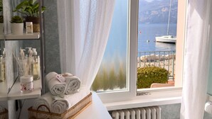 Ein Badezimmer mit Seeblick, einem Boot und einem Berg im Hintergrund.