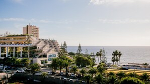 Een kusthotel met modern design, met een opvallende entree, parkeerplaats en uitzicht op de zee.
