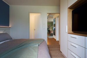 A bedroom with a bed, a bedside table, and a wardrobe.