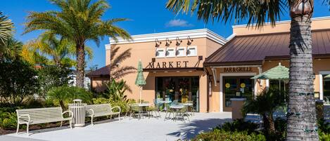 A building with a 'MARKET' sign, outdoor seating, and palm trees.