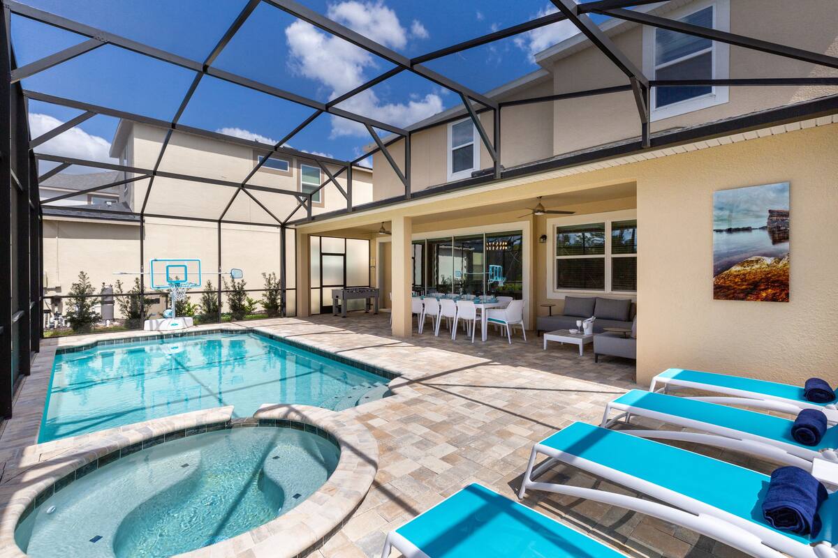 A pool area with two hot tubs and lounge chairs.