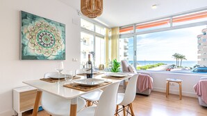 A dining area with a table set for two, a large window with a view of the sea, and a modern pendant light. - Cap Negret Altea la Olla - Altea, Altea, Costa Blanca (Altea)
