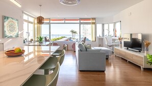 A modern living room with a large window, a dining area, and a TV on a wooden cabinet. - Cap Negret Altea la Olla - Altea, Altea, Costa Blanca (Altea)