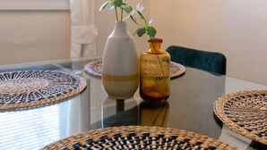 A dining table with woven placemats and two vases with flowers. - Historic Revival King Bed Midtown Memphis 68 (Memphis)