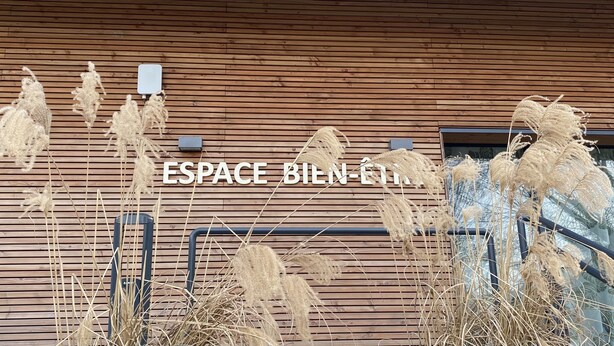A wooden wall with the text "ESPACE BILN-FIT" and decorative dried plants.