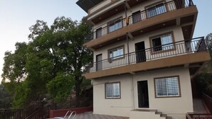 A multi-story building with a swimming pool and a covered terrace. - Royal Palace Panchgani (Mahabaleshwar)