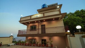 A two-story building with a balcony, potted plants, and a sign indicating it is a royal palace. - Royal Palace Panchgani (Mahabaleshwar)