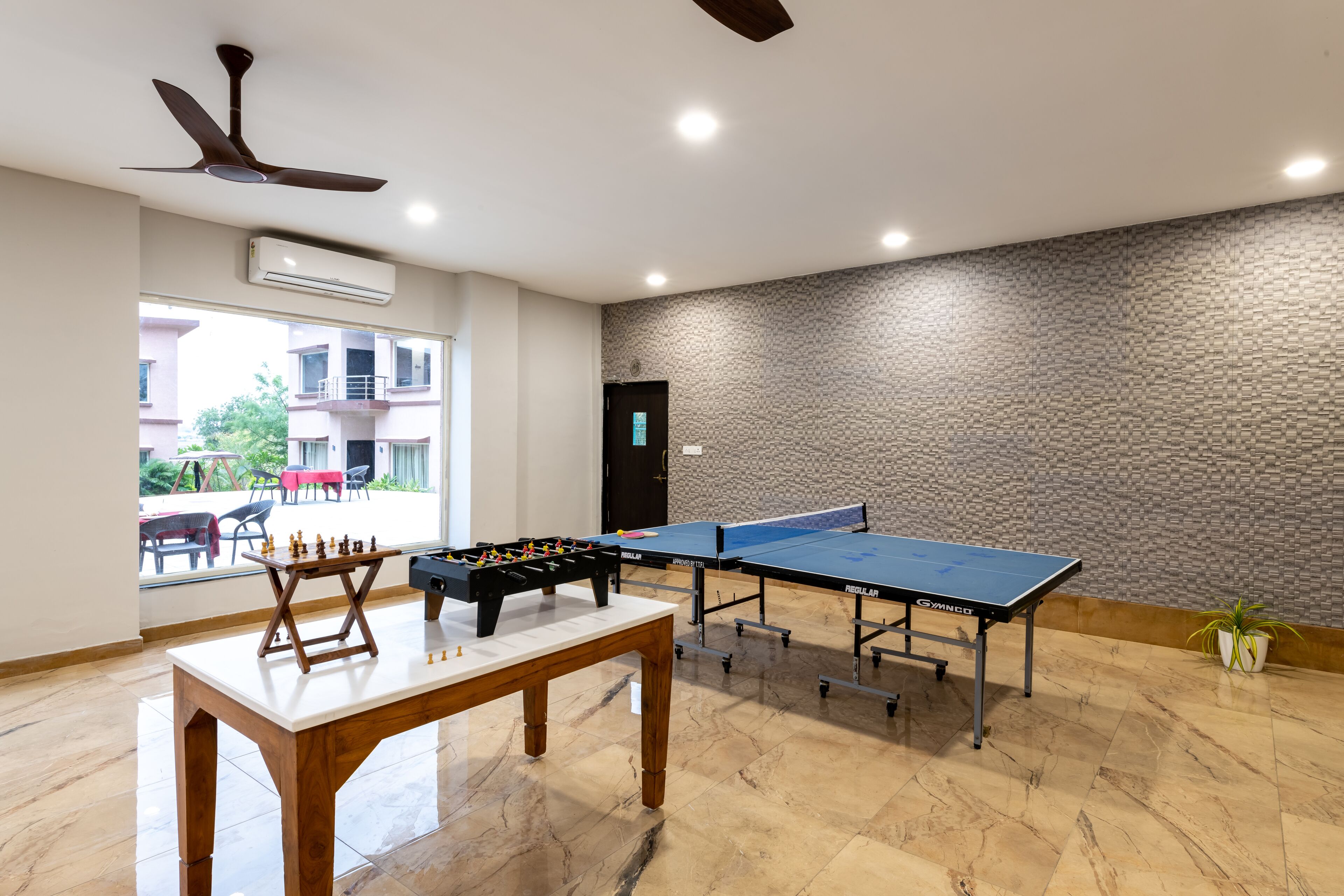Une pièce équipée d’un baby-foot, de tables de ping-pong et d’un jeu d’échecs.