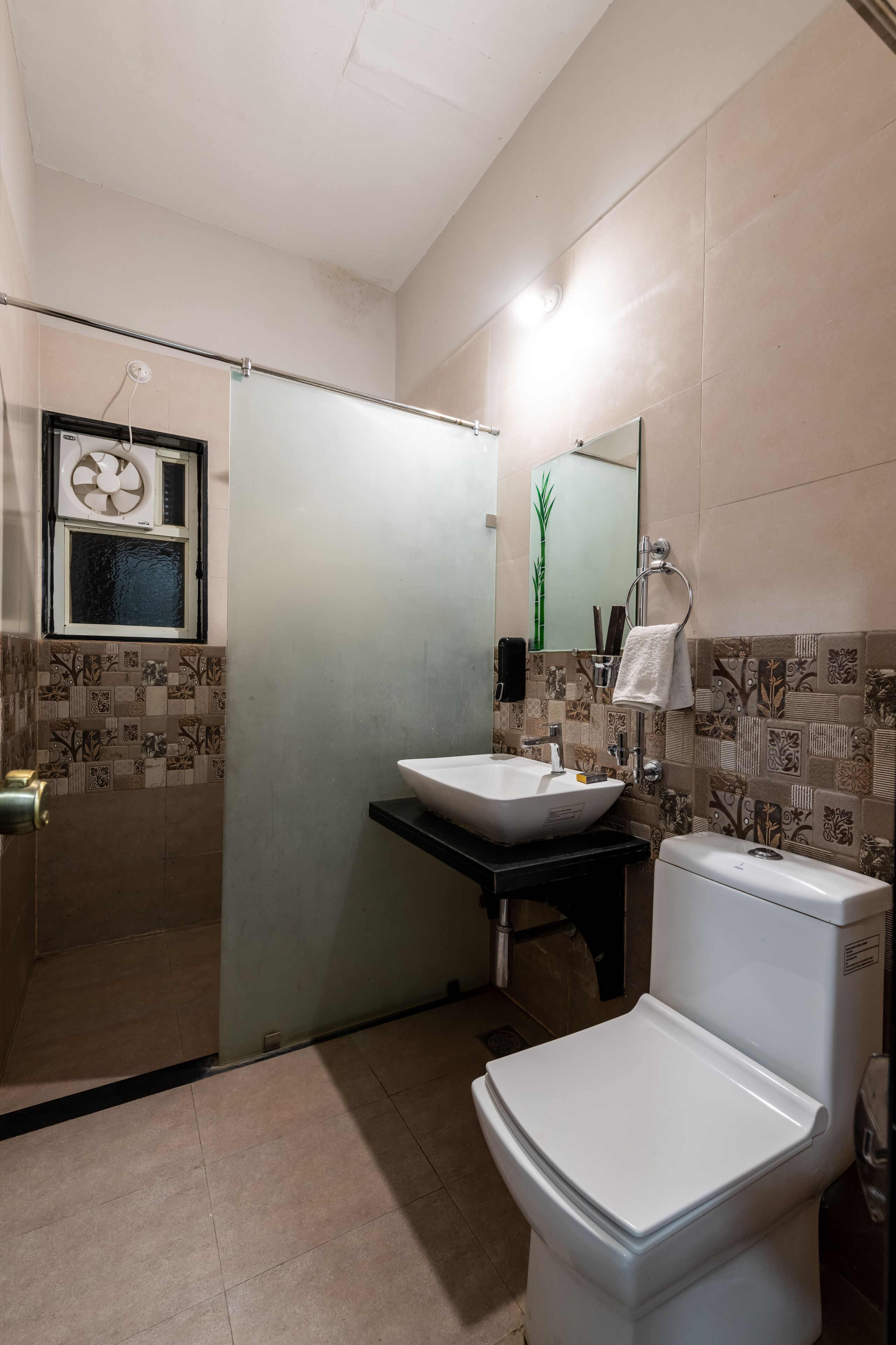 A bathroom with a toilet, sink, and shower area.