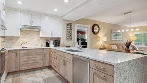 A modern kitchen with white cabinets, a granite countertop, and stainless steel appliances. - Saint James Place 333 3BR (Avon)