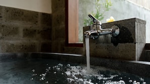 A bathroom with a stone sink and a faucet with water running into a basin. - Poka Ubud Hidden Paradise & Spa by EPS (Ubud)