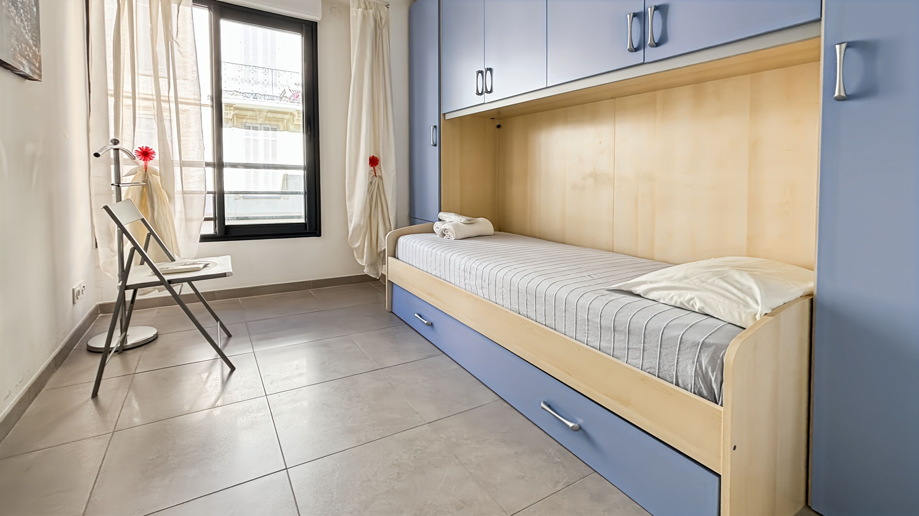 A bedroom with a bunk bed, a desk, and a chair.