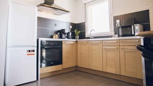 A modern kitchen with a built-in oven, a microwave, and a sink.