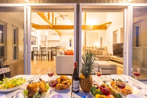 Una mesa de comedor con comida y bebidas, una botella de vino y una piña.
