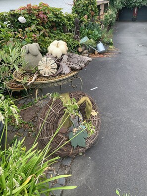 A garden pathway with decorative planters containing various plants and a small table with a woven basket. - The perfect getaway surrounded by greenery on an idyllic farm (Weilrod)