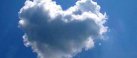Una nube con forma de corazón contra un cielo azul despejado.