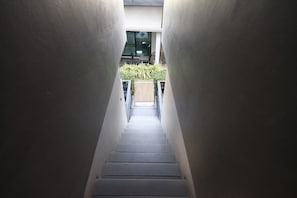 A narrow stairway leading to a balcony with outdoor seating. - The Seacret Kohlarn (Koh Lan)