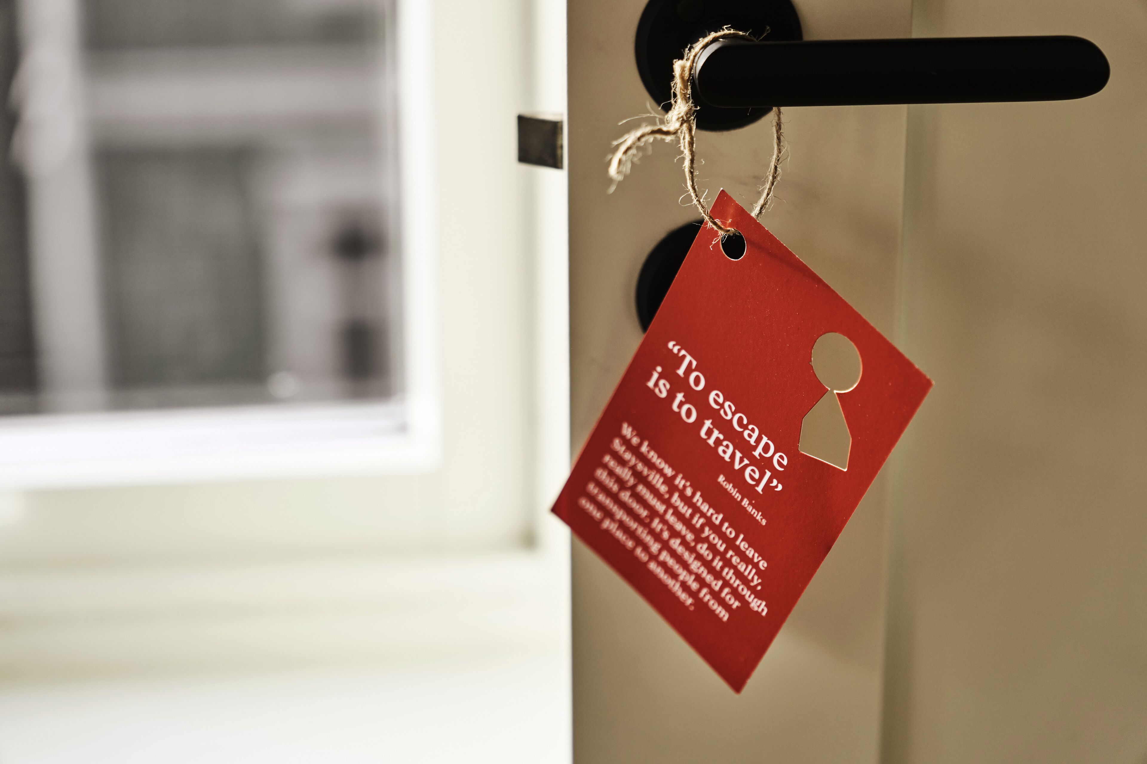 A red tag with a quote on a door handle.