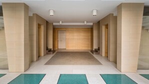 A hallway with beige walls, a central carpeted area, and a door at the end. - Suite La Giudecca (Gallipoli)