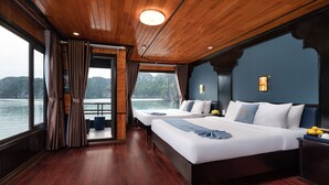 A cabin with two beds, wooden floors, and a view of the water. - La Pandora Boutique Cruise (Tuan Chau)