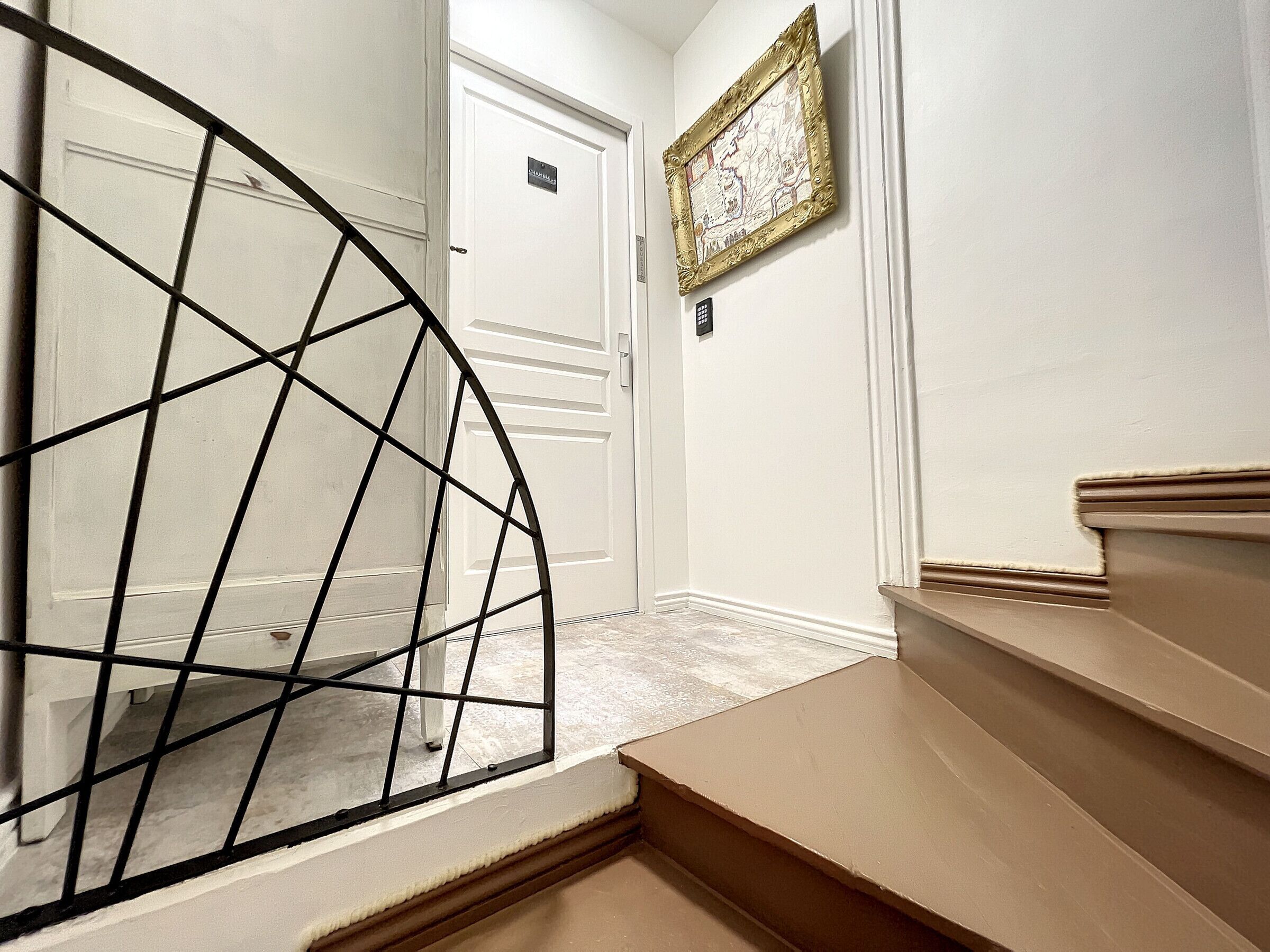 A staircase with a metal railing leading to a door.