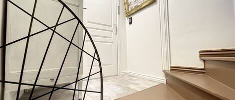 A staircase with a metal railing leading to a door.