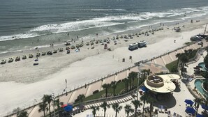 Una playa con sombrillas, una piscina y una torre de salvavidas.