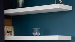 A room with white floating shelves against a teal wall, holding framed pictures, a glass vase, and books. - Stylish Apartment in Wola | 450 m to the Metro, Balcony (Warszawa)