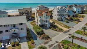 Uma área residencial costeira com casas, uma praia e céu claro.