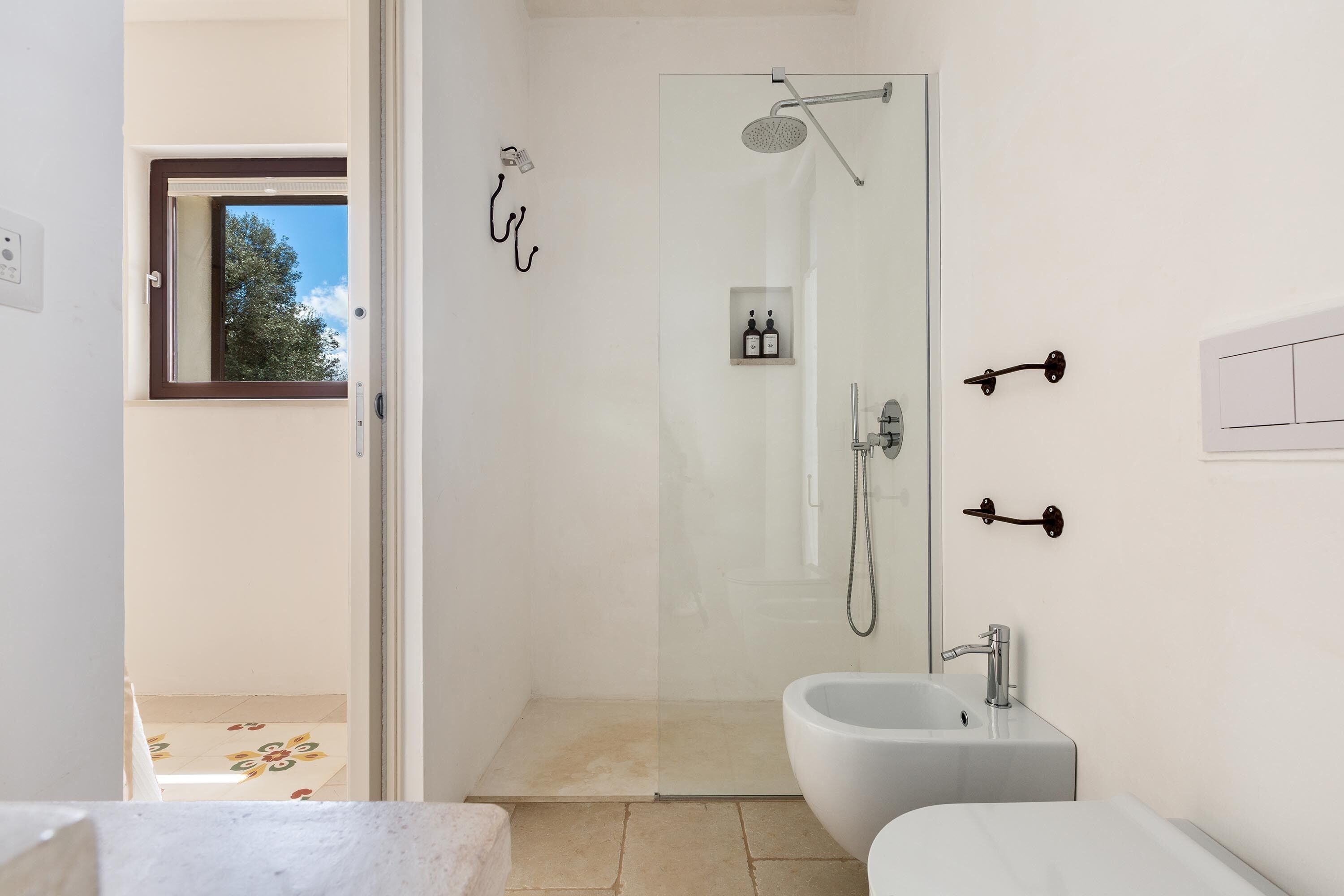 Une salle de bain moderne avec une douche à parois de verre, un bidet et des toilettes.