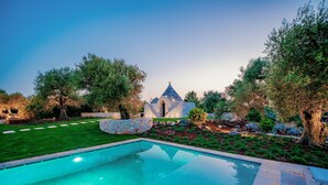 A swimming pool with a stone structure in the background. - 3155 Villa Pietralunga by Perle di Puglia (Ostuni)