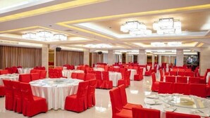 A banquet hall with round tables, red chairs, and chandeliers. - Zhongnan Hotel (Nan'an)