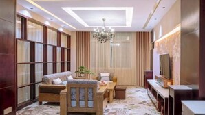 A modern living room with a sofa, a dining table, and a TV. - Zhongnan Hotel (Nan'an)
