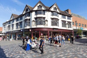 A historic building with a corner entrance, multiple windows, and a ground-level seating area. - Impeccable 2-bed Apartment in Derby, England (Derby)