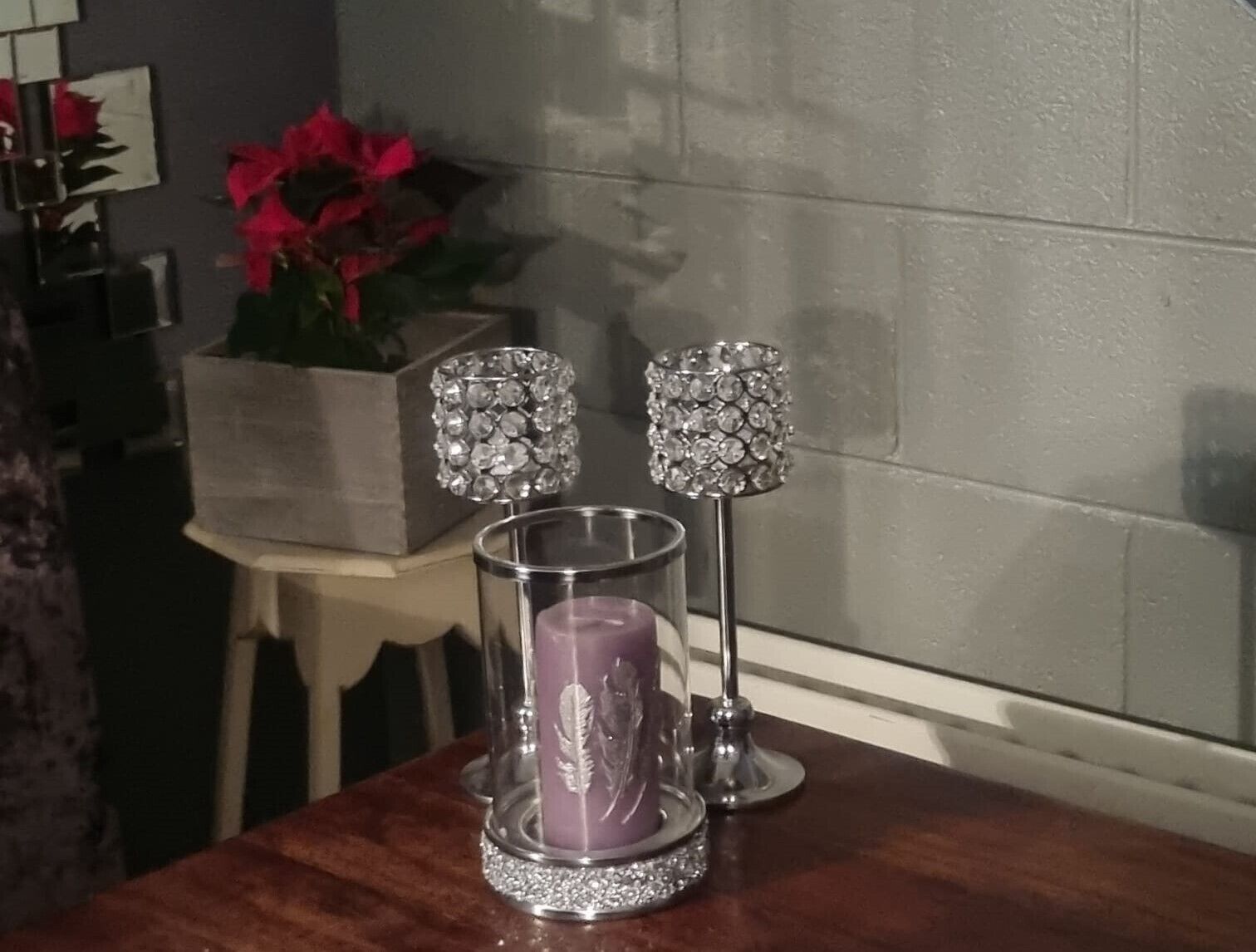 Une table avec un chandelier, une bougie en verre et deux lampes décoratives.