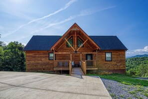 A wooden cabin with a steeply pitched roof, a front porch, and a driveway leading to the entrance. - 2 Miles to all the action-fire pit-views! (Sevierville)