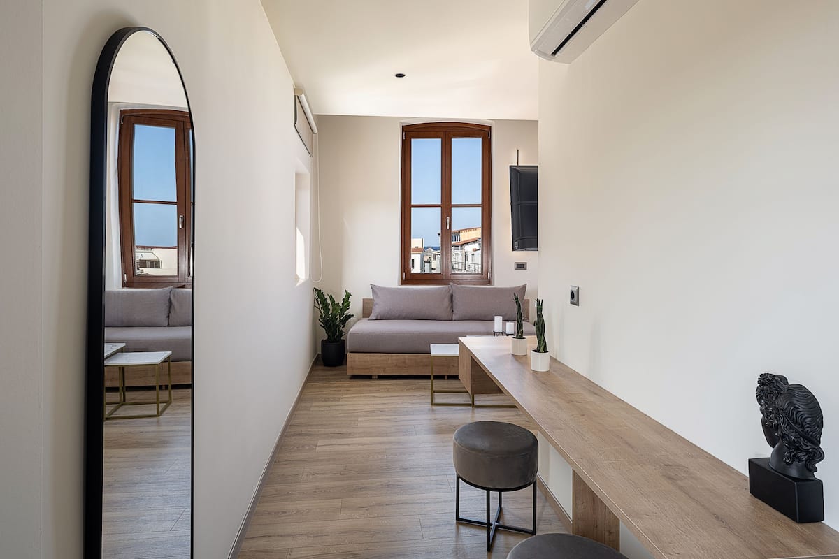 A modern living room with a sofa, a coffee table, and a dining area.