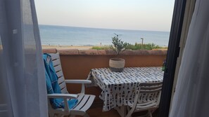 A balcony with a table and chairs, overlooking a beach with people in the distance. - Absolute beach front apartment Plage Roquille Fabulous Views Direct beach access (Agde,)