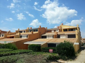 A residential building with multiple balconies, a tiled roof, and a sign indicating a private property. - Absolute beach front apartment Plage Roquille Fabulous Views Direct beach access (Agde,)