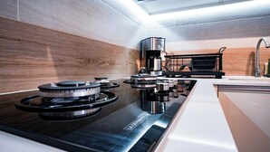 Une cuisine moderne équipée d’une cuisinière à gaz, d’une machine à café et d’un évier.