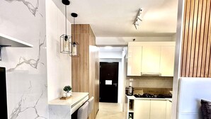 Une cuisine moderne avec des armoires blanches, un plan de travail en bois et une cuisinière intégrée.