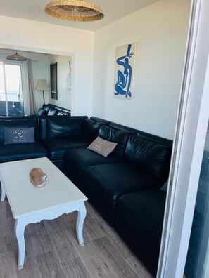 A living room with a black leather sofa, a white coffee table, and a wicker ceiling light. - Sea view & beach at foot 4 bedrooms ideal for families (Quiberon)