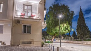 Un edificio de varios pisos con un balcón, una maceta y un farol.