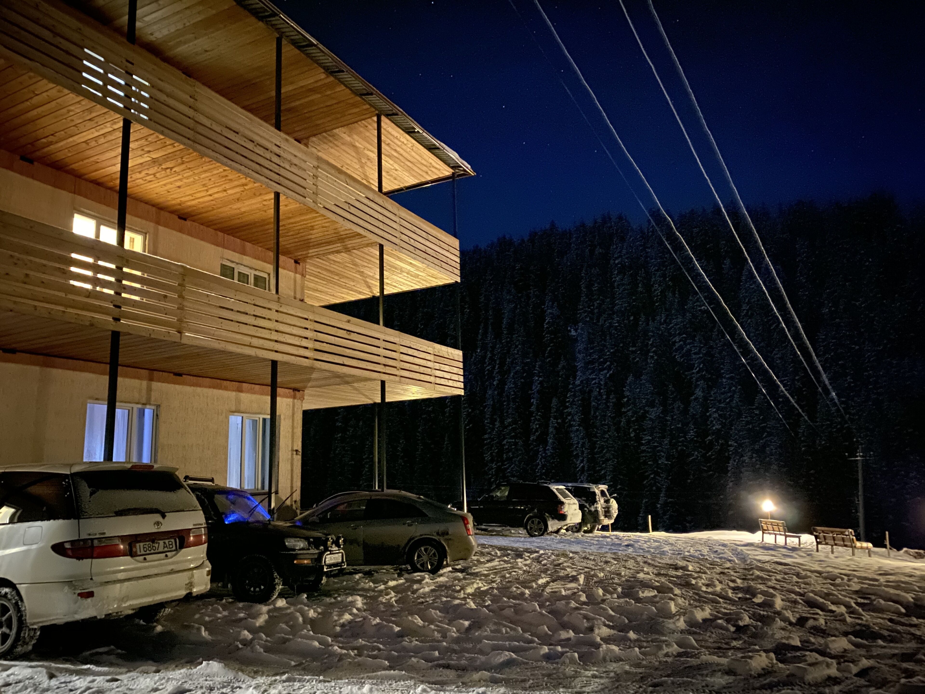 A multi-story building with a wooden facade and a snowy ground.
