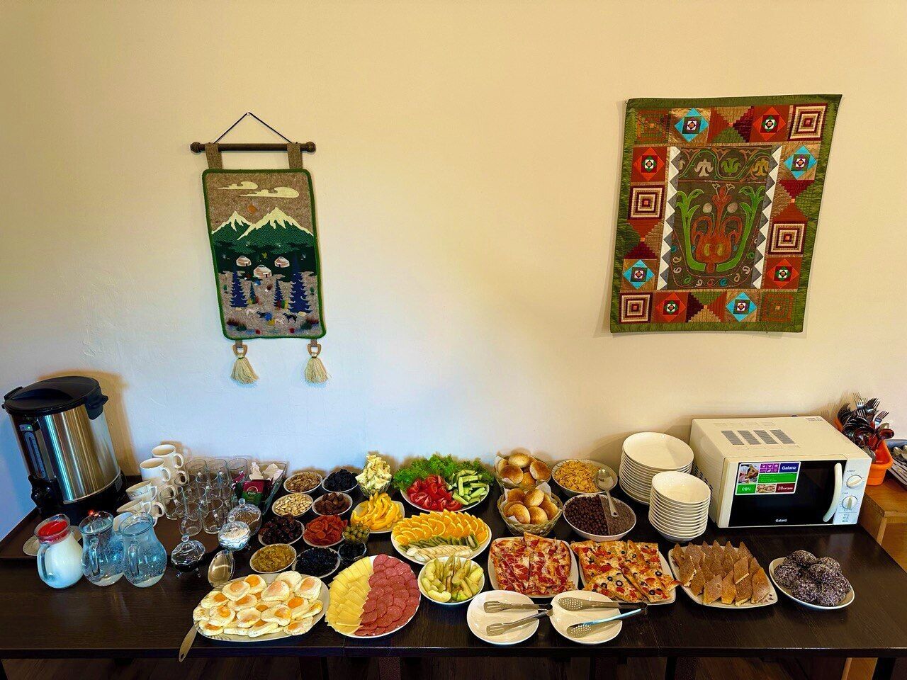 A buffet table with various food items and a coffee maker.