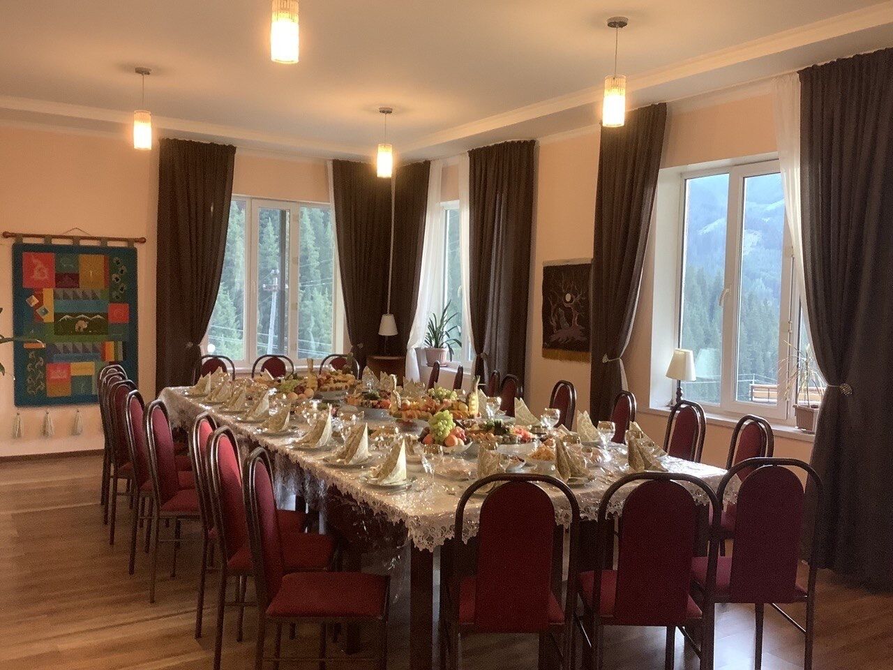 A dining room with a long table set for a meal, surrounded by chairs.