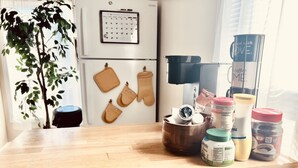 A kitchen with a wooden countertop, a plant, hanging oven mitts, and various kitchen items. - A Cozy, Homely, Fun Retreat minutes from downtown (Rochester)