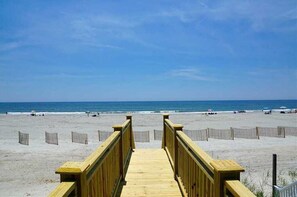 A wooden boardwalk leading to a beach with a clear view of the ocean. - Hobbs Realty - "Salty Kisses" is a beautiful oceanfront home with a private pool. (Holden Beach)