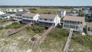 A coastal residential area with houses featuring balconies and wooden walkways.