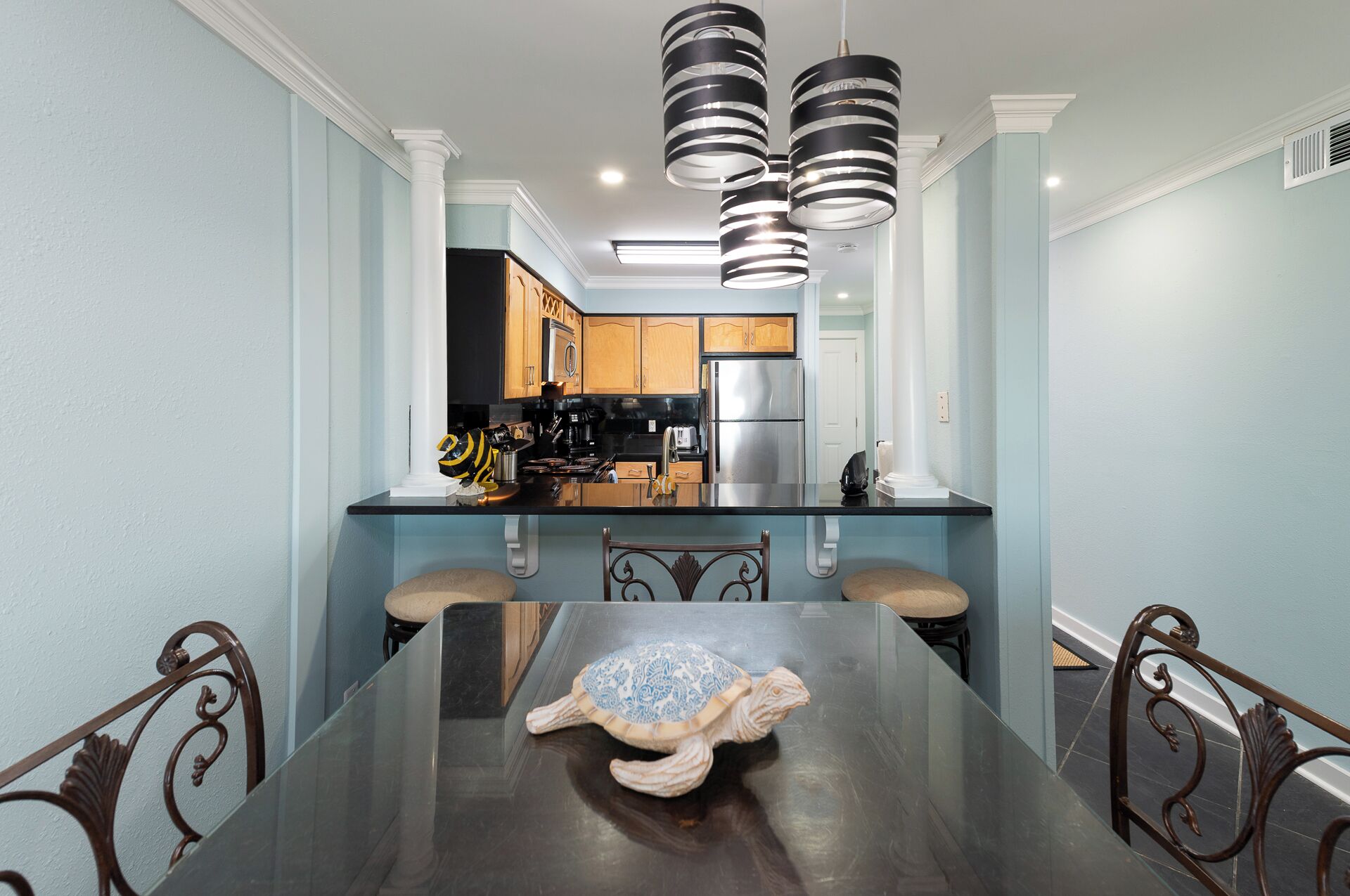 A dining area with a dark wooden table, two chairs, and a decorative turtle centerpiece.